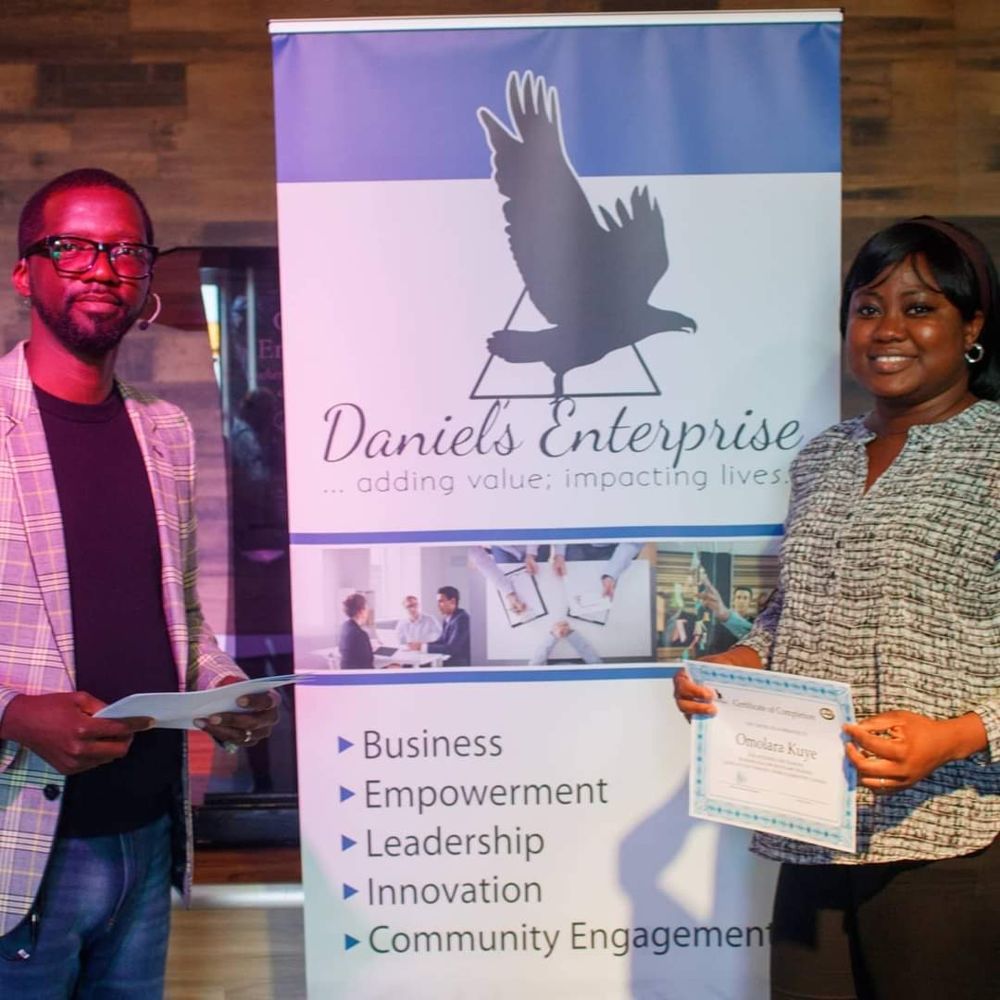 Certificate presentation in front of the Daniel's Enterprise banner